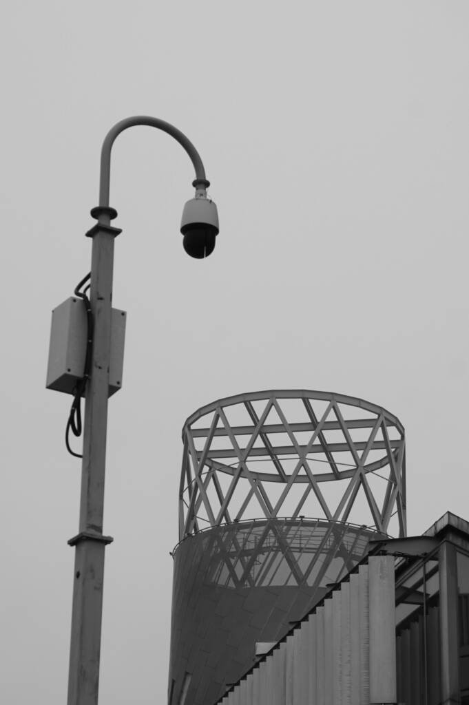 Security camera on a pole with a building in the background