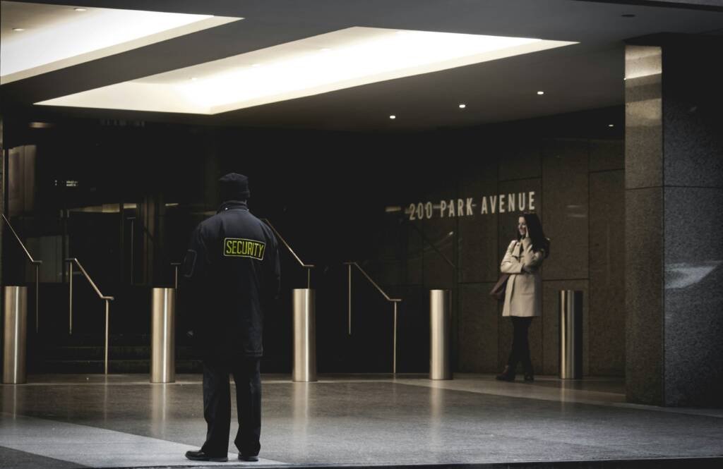 Security guard standing in a building foyer by the entrance